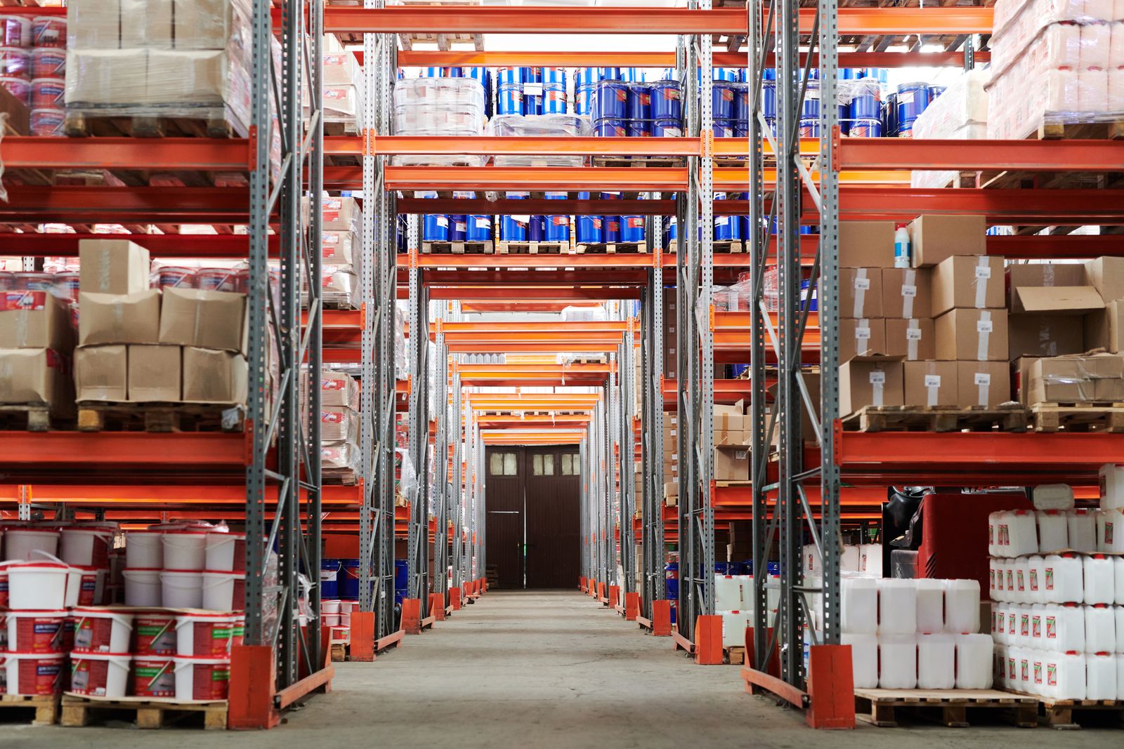 Warehouse aisle lined with shelves of cartons and stored goods